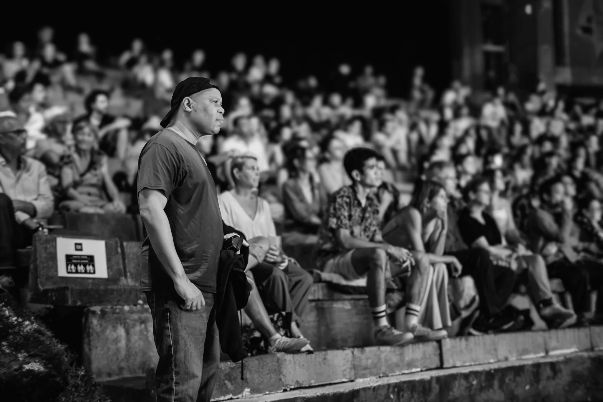 Black-and-white photograph of Steve Coleman beside an audience at an outdoor performance.