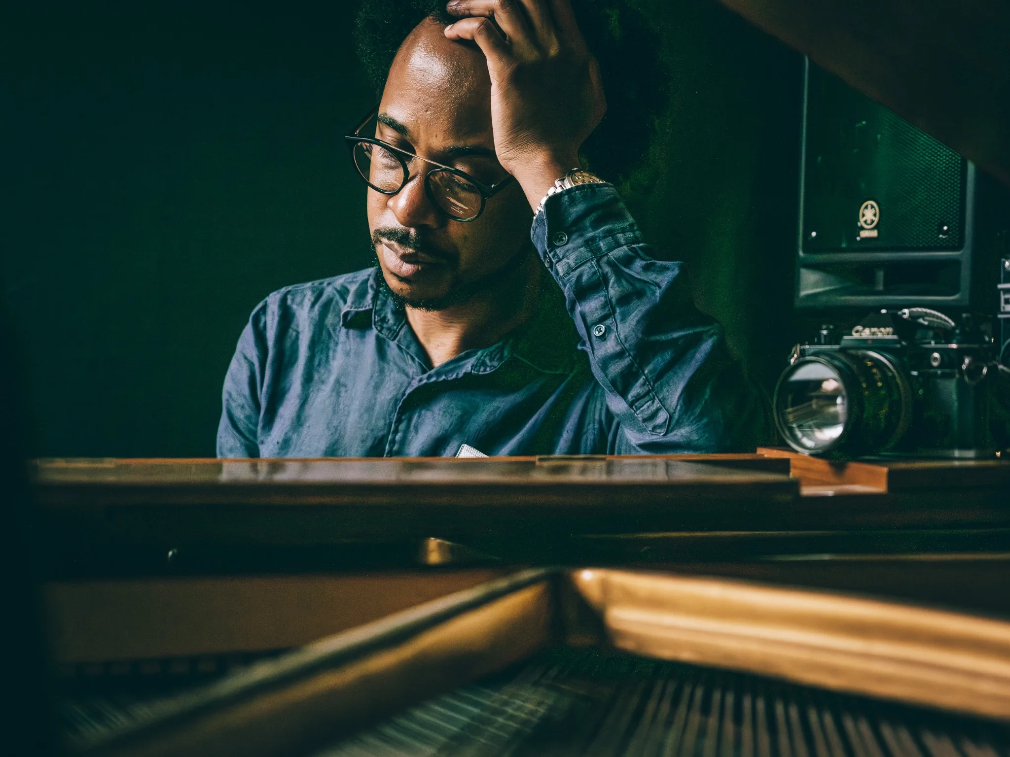Jonathan Finlayson seated beside a piano, with a camera nearby.