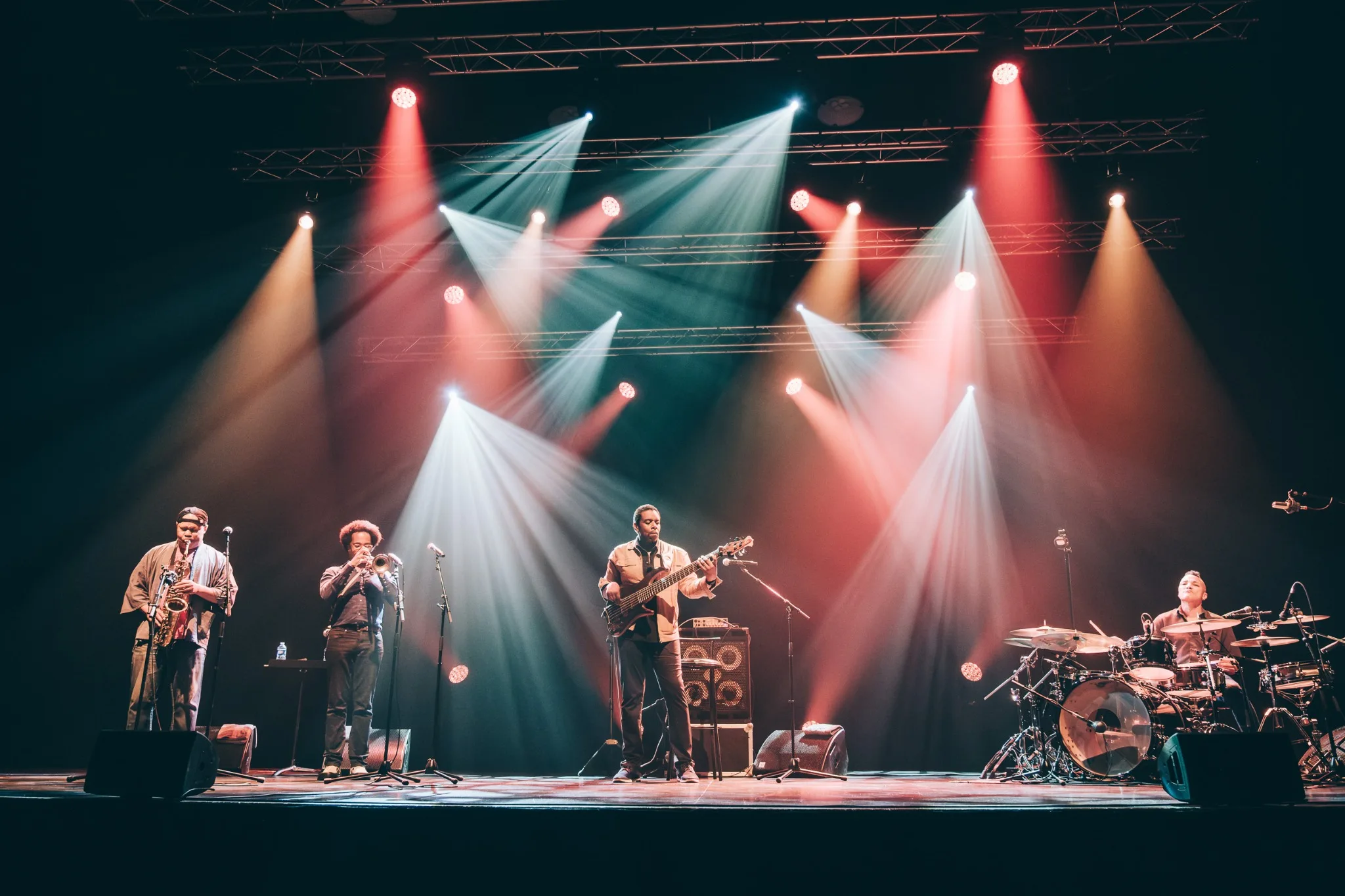 Five Elements performing beneath red and white stage lights in Rennes.