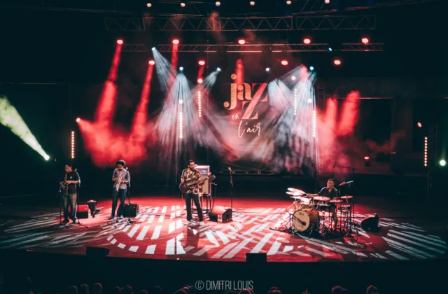 Wide view of Five Elements performing beneath red and white lights at Jazz en l’Air.