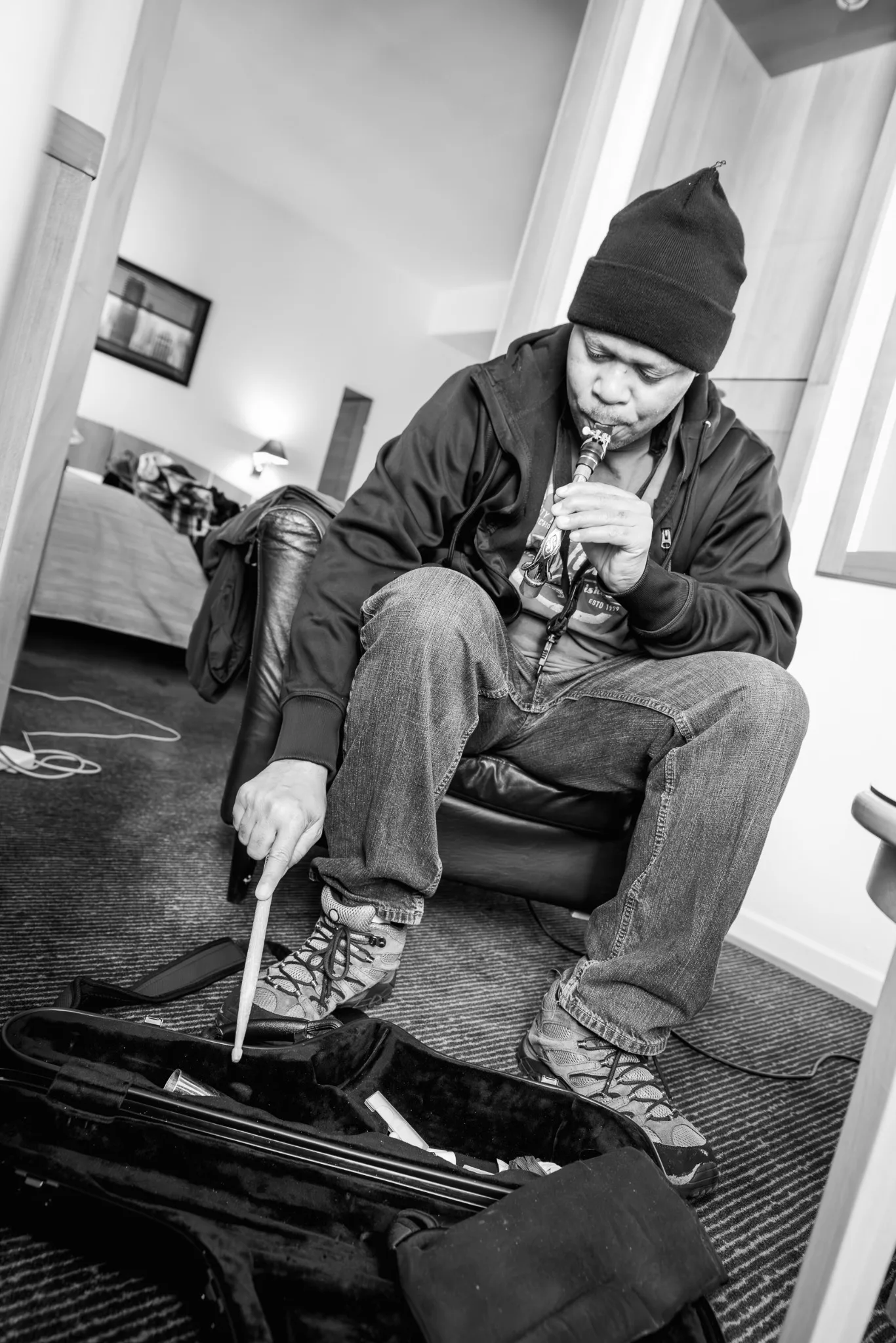 Black-and-white photograph of Steve Coleman seated with a saxophone and equipment nearby.